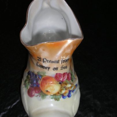 Porcelain Boot or Shoe. Picture on the front is of fruit and the wording 21 Present from Canvey on Sea. Lenth is 5inch Width 3inch. The wording on the base ME Bavaria 18 | Carol Rowles