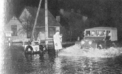 A patrolman directing traffic on the flooded main road of Canvey Island, along which all relief vehicles pass during the initial rescue work on the island