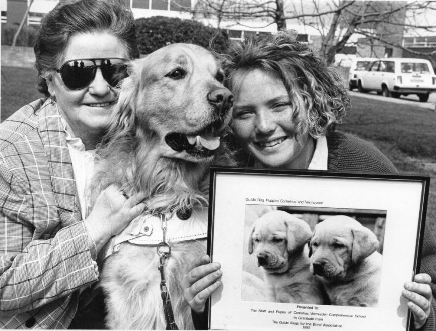 Fur you: Dolly Allen, with adult guide dog Bobby, presents pupil Louise Curtis wiyj a picture of the two puppies | Echo Newspaper Group