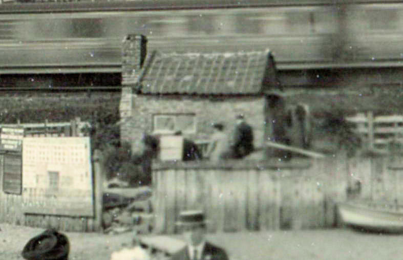 Old ferry cottage with train passing by.